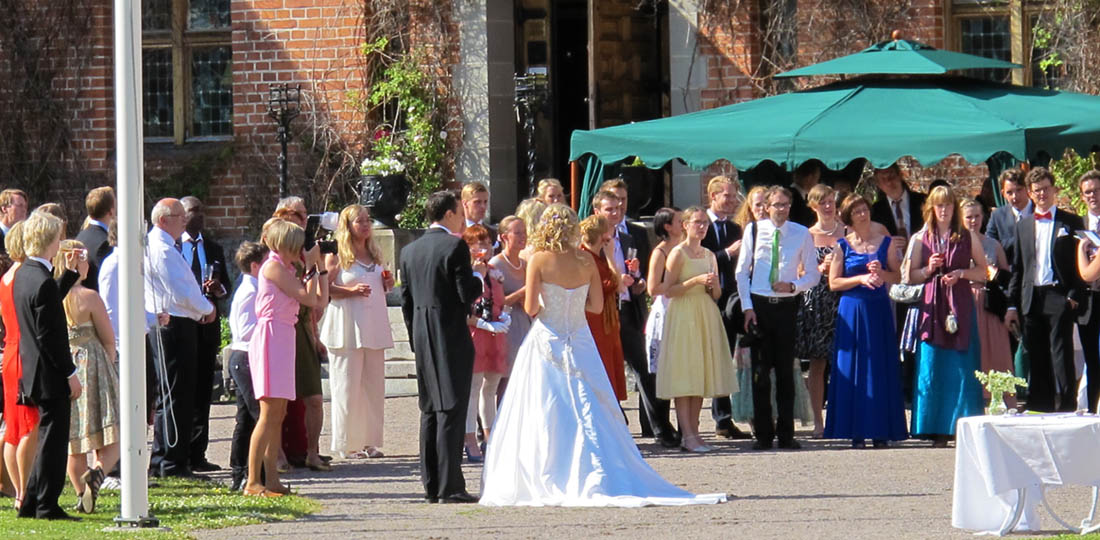 Brudskål framför slottet med brud i vit bröllopsklänning
