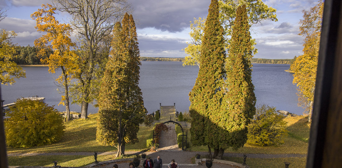 Utsikt över sjön Båven med stenbrygga och slottspark