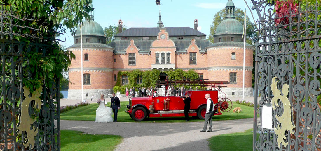 Bröllopsfotografering med gammal brandbil framför slottet