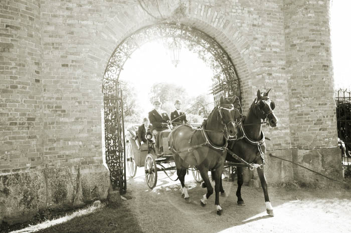 Brudpar i häst och vagn genom portalen